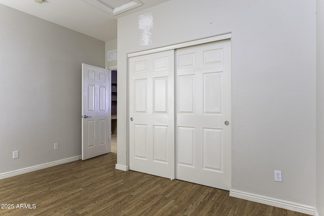 unfurnished bedroom with dark hardwood / wood-style floors and a closet