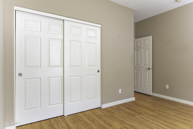 unfurnished bedroom featuring a closet and light hardwood / wood-style flooring