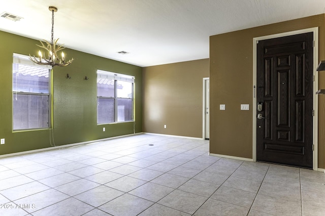 foyer with light tile patterned floors and a notable chandelier