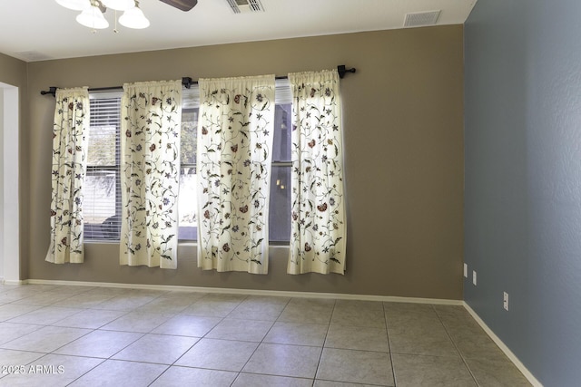 tiled spare room featuring ceiling fan