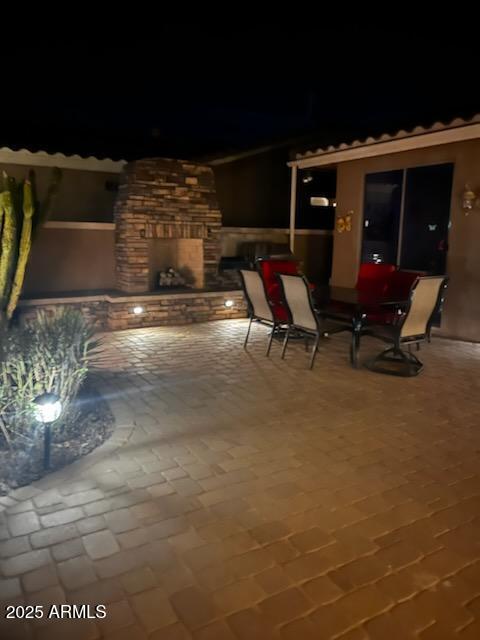 patio at night with a stone fireplace