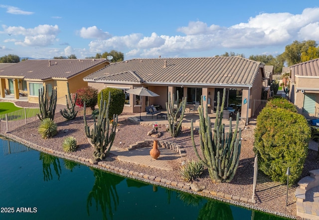 rear view of house featuring a patio area and a water view