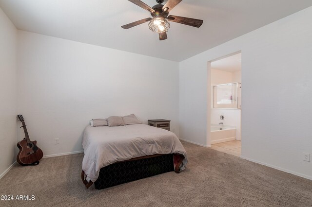 bedroom featuring light carpet, ceiling fan, and ensuite bath