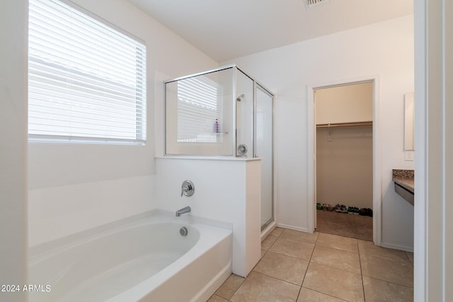 bathroom featuring tile floors, a wealth of natural light, vanity, and shower with separate bathtub