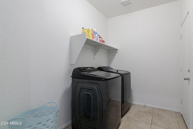 laundry area featuring separate washer and dryer and light tile flooring