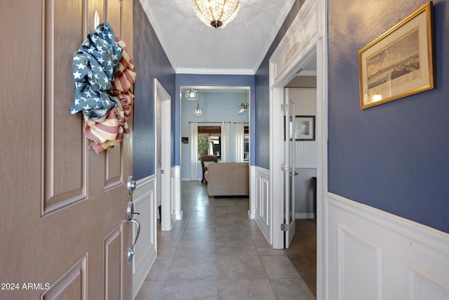 entryway with light tile patterned floors, ceiling fan, and ornamental molding