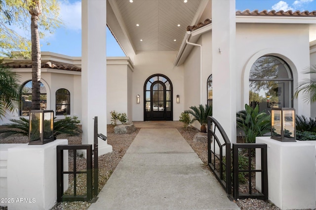 entrance to property with a tiled roof and stucco siding