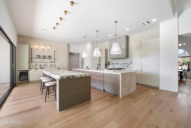 10541 E Windrose Dr, Scottsdale, AZ 85259 - kitchen with a spacious island, beverage cooler, pendant lighting, and modern cabinets