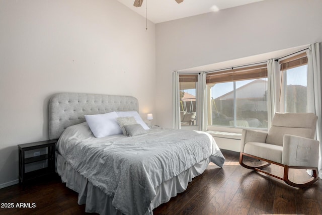 bedroom featuring dark wood-style floors, baseboards, and vaulted ceiling