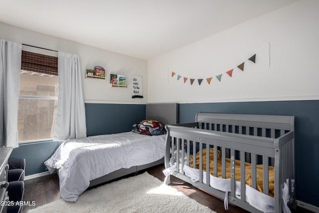 bedroom with multiple windows and wood finished floors