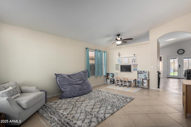 living area with arched walkways, french doors, tile patterned flooring, and lofted ceiling