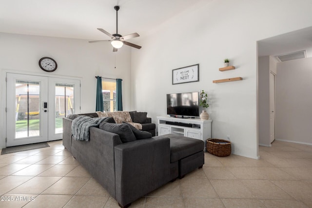 living room with ceiling fan, light tile patterned flooring, a high ceiling, visible vents, and french doors