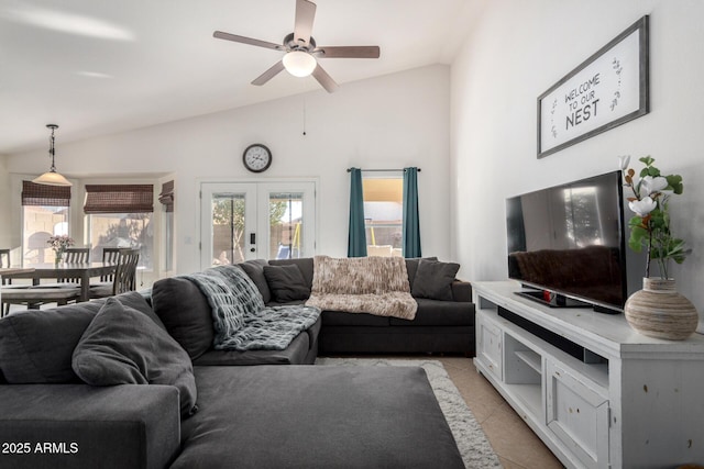 living area with vaulted ceiling, french doors, light tile patterned floors, and a ceiling fan