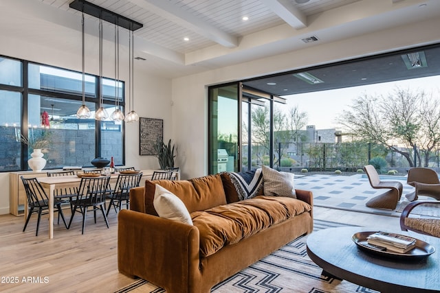 living area with light wood-type flooring, beam ceiling, visible vents, and recessed lighting