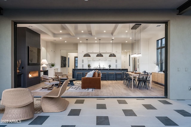 interior space with light floors, a fireplace, beam ceiling, and recessed lighting