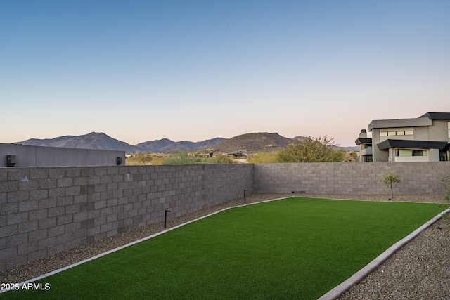 view of yard with a fenced backyard and a mountain view