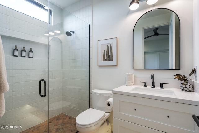 bathroom featuring a stall shower, vanity, and toilet