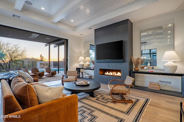 living room with visible vents, wood finished floors, a fireplace, beam ceiling, and recessed lighting