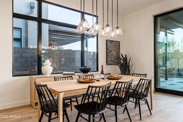 dining space featuring light wood-type flooring, baseboards, and a wealth of natural light