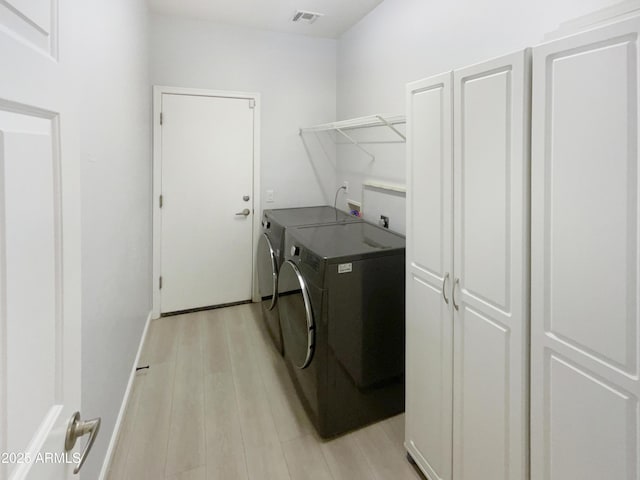 washroom featuring separate washer and dryer and light hardwood / wood-style floors