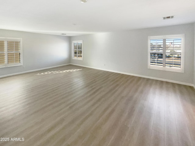 unfurnished room with hardwood / wood-style flooring and plenty of natural light