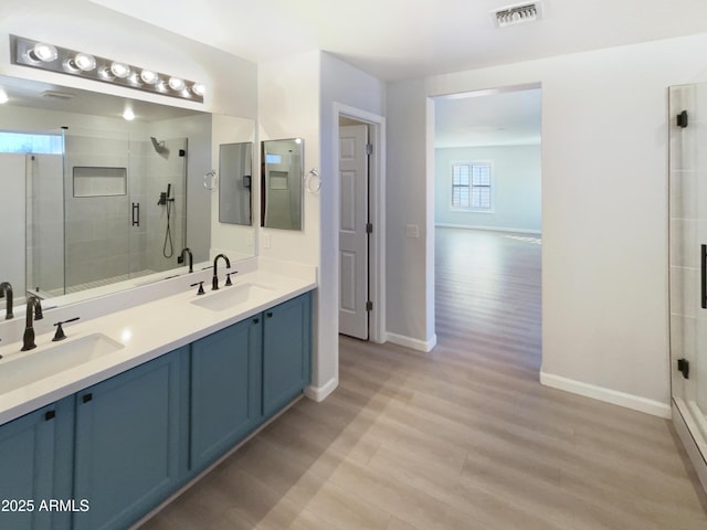 bathroom featuring a shower with door, vanity, and hardwood / wood-style floors