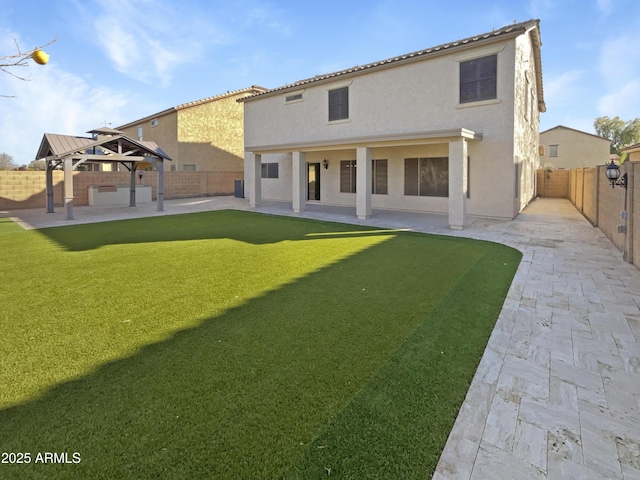 back of house with a gazebo, a yard, and a patio area