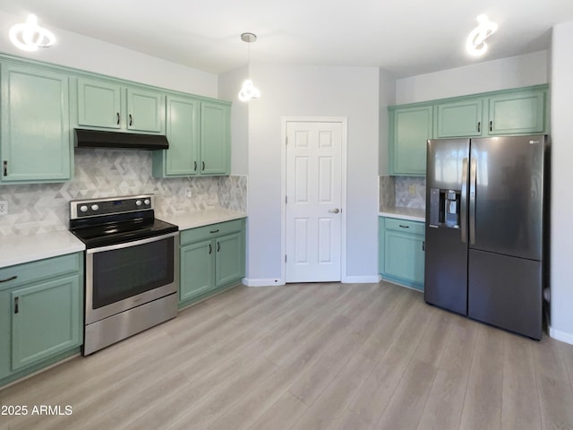 kitchen featuring pendant lighting, green cabinets, appliances with stainless steel finishes, light hardwood / wood-style floors, and decorative backsplash