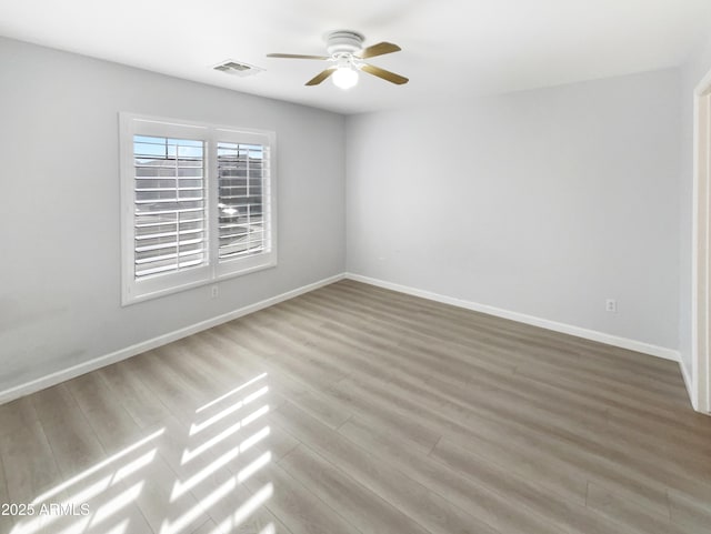 empty room with hardwood / wood-style flooring and ceiling fan