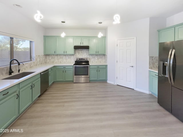 kitchen featuring hanging light fixtures, stainless steel appliances, sink, and green cabinetry