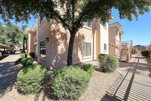 10030 W Indian School Rd Unit 101, Phoenix, AZ 85037 - view of side of home with stucco siding and stairway