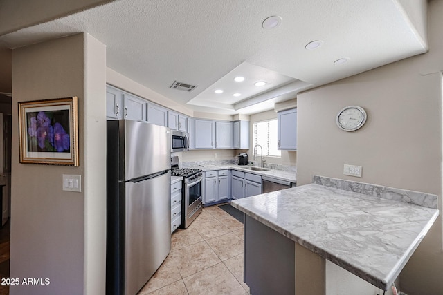 10030 W Indian School Rd Unit 101, Phoenix, AZ 85037 - kitchen with stainless steel appliances, a peninsula, light countertops, light tile patterned floors, and recessed lighting