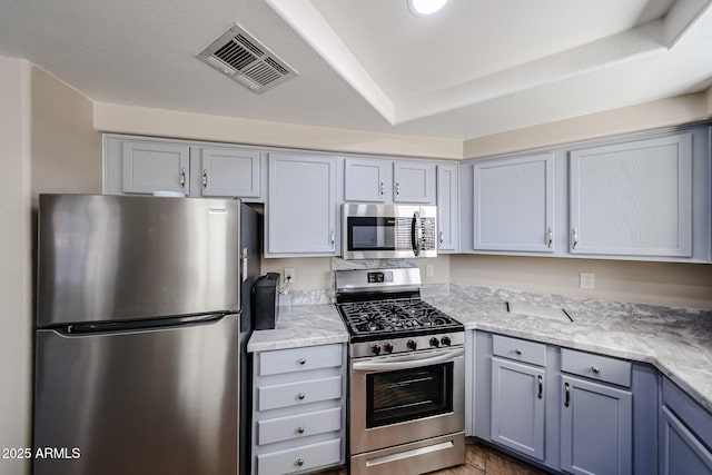 10030 W Indian School Rd Unit 101, Phoenix, AZ 85037 - kitchen with stainless steel appliances, gray cabinetry, and light stone counters