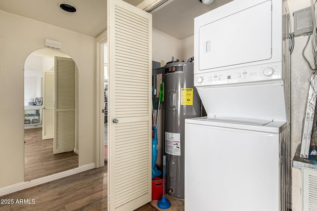 839 S Westwood Unit 287, Mesa, AZ 85210 - washroom with stacked washer / dryer, electric water heater, wood finished floors, baseboards, and arched walkways