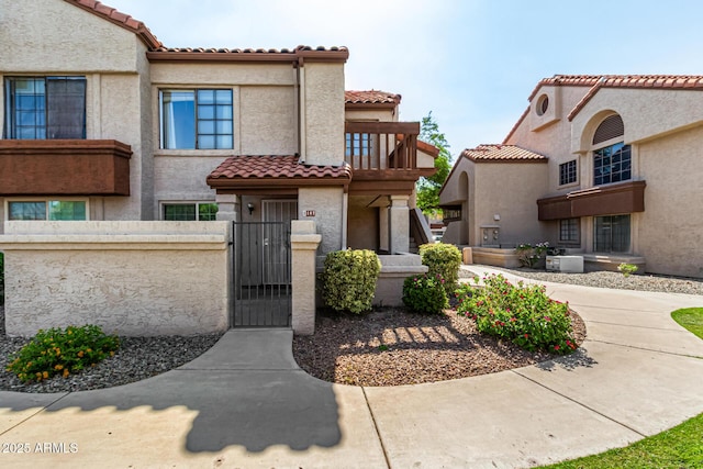 839 S Westwood Unit 287, Mesa, AZ 85210 - view of front facade with a fenced front yard, a gate, a tile roof, and a balcony