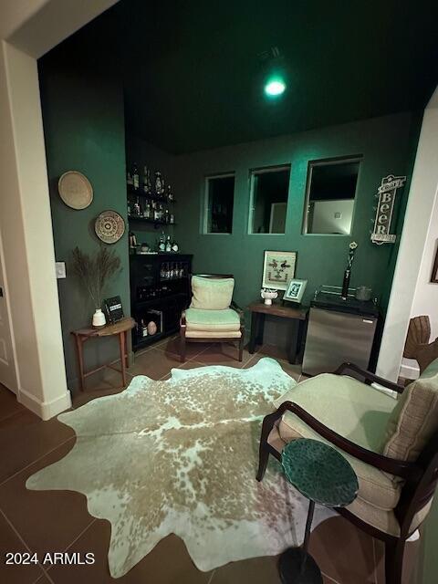 sitting room featuring tile patterned flooring and indoor bar