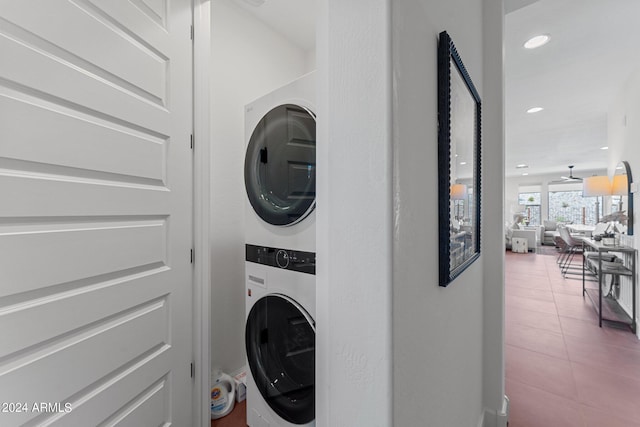 laundry area featuring stacked washer / dryer and tile patterned flooring