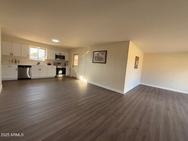 unfurnished living room featuring dark wood-type flooring and sink