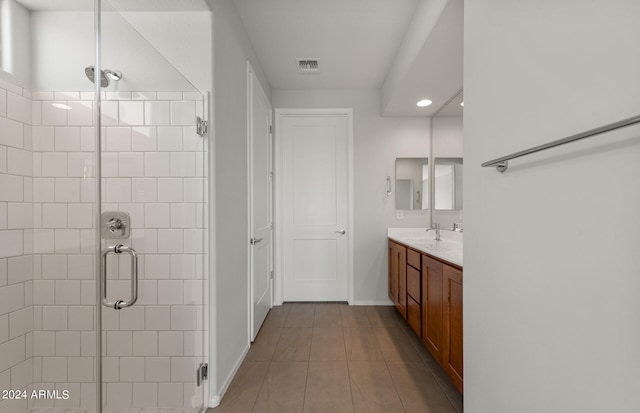 bathroom featuring a shower with door, vanity, and tile patterned flooring