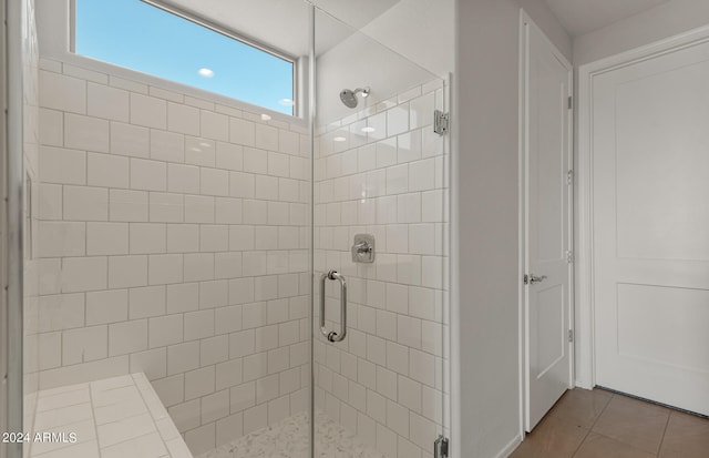 bathroom featuring a shower with door and tile patterned flooring