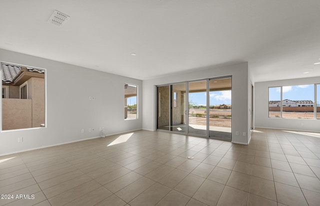 tiled spare room with a healthy amount of sunlight