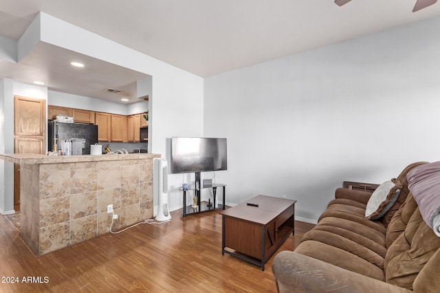 living room with ceiling fan and dark hardwood / wood-style flooring