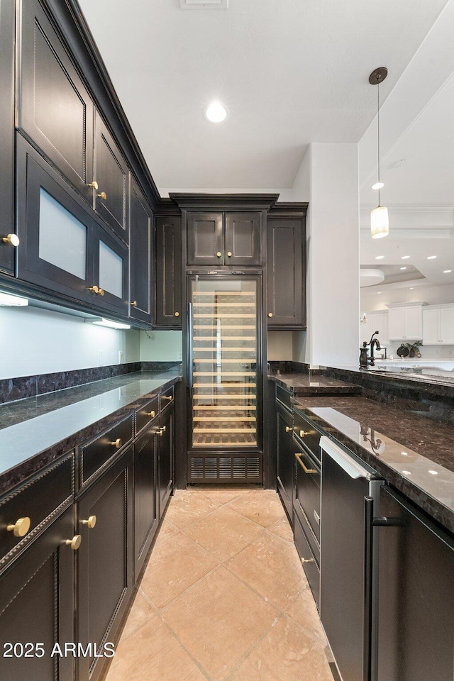 kitchen with decorative light fixtures, sink, stainless steel fridge, light tile patterned floors, and dark stone counters