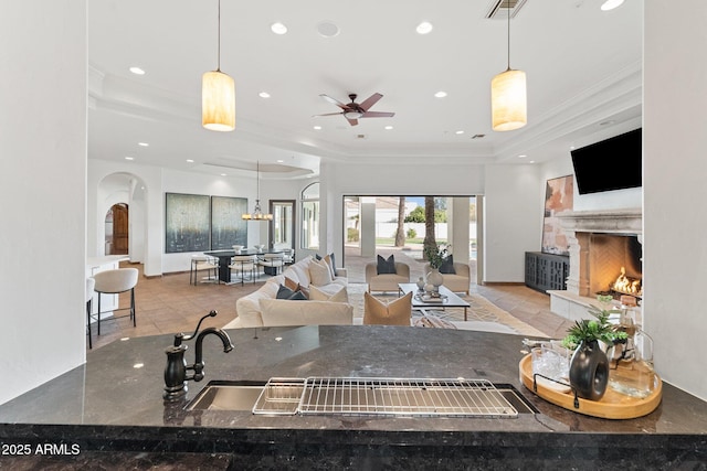 kitchen featuring decorative light fixtures, light tile patterned floors, a tray ceiling, and ceiling fan