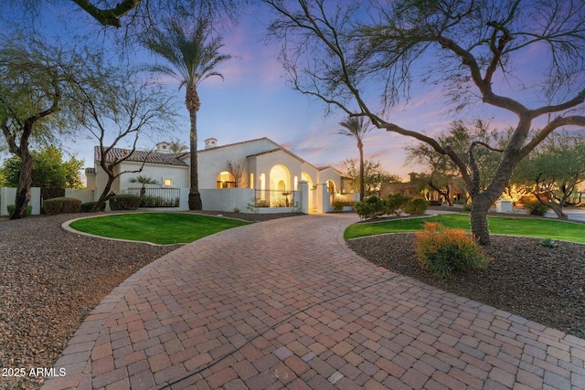 mediterranean / spanish house featuring a yard