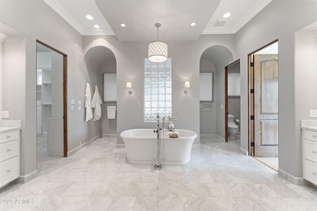 bathroom with toilet, vanity, a bathtub, and crown molding