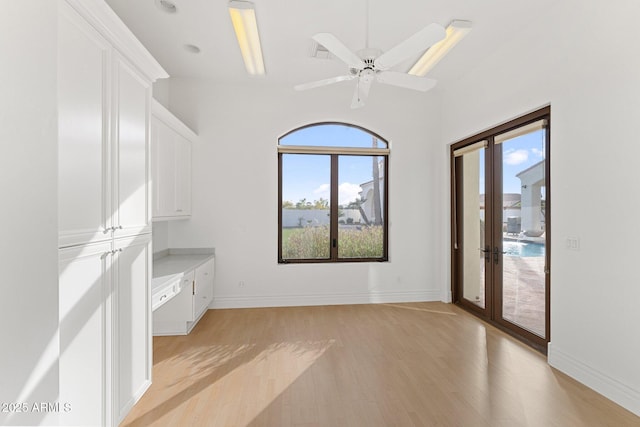 interior space with light wood-type flooring, ceiling fan, and french doors