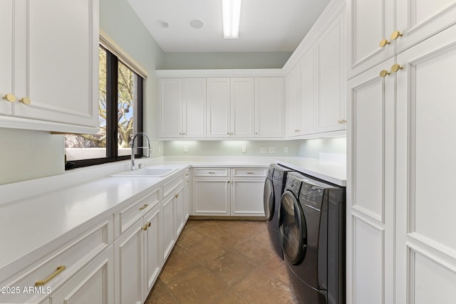 washroom featuring cabinets, washing machine and clothes dryer, and sink