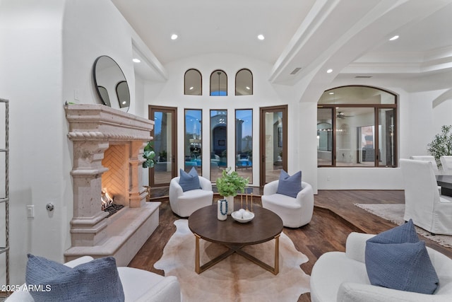 living room with vaulted ceiling, a premium fireplace, wood-type flooring, and ceiling fan