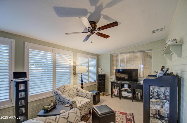 living room with ceiling fan, lofted ceiling, and carpet flooring